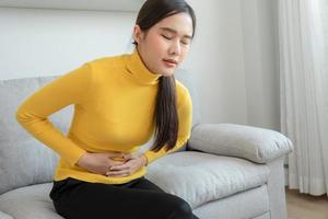 stomach ache. Asian women have abdominal pain, indigestion, gastritis, menstrual cramps, flatulence, diarrhea, distention, colon cancer, belly inflammation problem, suffer food poisoning, abdomen photo