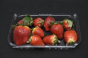 Large red strawberries in plastic packaging. Delicious red berry. photo