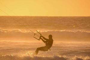 kitesurfer a puesta de sol foto