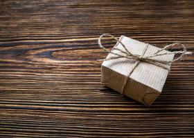 sorpresa regalo. un Kraft papel caja atado con yute cuerda en un viejo, de madera antecedentes foto