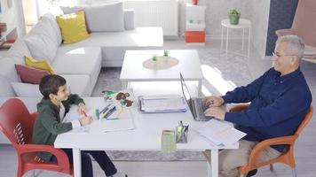 vader werken van huis en zoon aan het studeren. Mens werken van huis zittend Bij tafel met zoon tekening. video