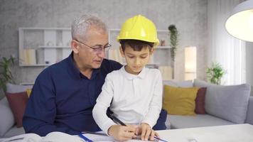 The younger son is helping his engineer father. Little Son helps his father with his business. video