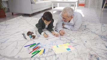 Vater hilft seine Sohn mit seine Hausaufgaben. Vater und Sohn zeichnen Bilder und tun Hausaufgaben beim heim.