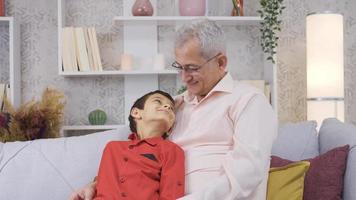 padre e figlio sorrisi guardare a telecamera. contento padre e figlio guardare a telecamera e sorridente. video