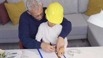 content père et fils. le parent travail à Accueil aussi prend se soucier de leur enfant. le père est en essayant à travail et jouer à le même temps avec le enfant à maison. video