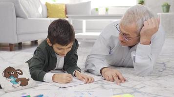 Happy father and son do homework at home and get along well. Cute father helping his son with his homework. video