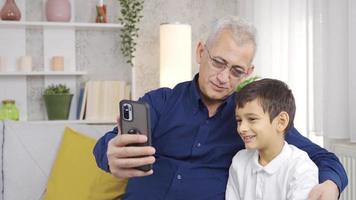 père et fils vidéo bavarder sur le téléphone ensemble. content père et fils parlant sur téléphone vidéo bavarder ensemble à maison. video