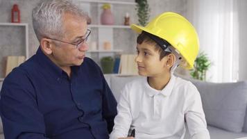 feliz pai e filho. pequeno filho ajudando engenheiro pai. a mais jovem filho é ajudando dele engenheiro pai. video