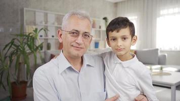 père et fils à la recherche à caméra et souriant. mature père et fils souriant à la recherche à caméra. video