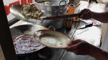 People prepare batagor by frying it. Batagor is a traditional Indonesian food made from mashed tofu, filled with a dough made from mackerel and tapioca flour. video