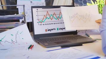 zakenman werken met diagram gegevens. zakenman op zoek Bij financieel verklaringen en statistieken gedrukt Aan papier Aan een laptop. video