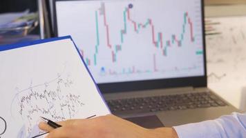 näringsidkare ser på digital och dragen stock marknadsföra diagram. man analyserar marknadsföra data information. video