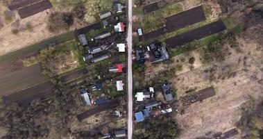 flight over and aerial panoramic view of green village with houses, homestead, barns, greenhouses and gravel road video