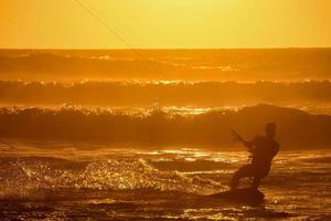 kitesurfer a puesta de sol foto