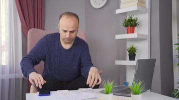 preocupado homem vencimento para financeiro problemas olhando às contas e banco dívidas. homem fazendo financeiro Cálculo dentro casa economia é dentro dívida e desesperado. video