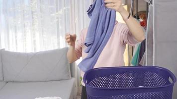 schmutzig Wäscherei. Hausfrau setzt ihr Kleider im ihr schmutzig Korb. video