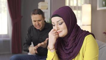 muçulmano mulher dentro hijab é choro. família problemas. a homem grita às dele velado esposa e repreensões dela e faz dela chorar. video