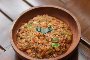 a close up Rujak Bebek or smashed fruit which is made from raw fruit crushed in a mortar and pestle and added with shrimp paste, chili and brown sugar. Indonesian traditional food photo concept.