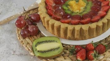 grande Fruta tarta con coberturas de fresas, uvas, kiwi y piña. sabroso, dulce y fresco. comida concepto foto. foto