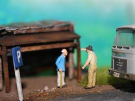 un cerca arriba de un miniatura figura de un antiguo hombre hablando a otro personas en un antiguo edificio por el lado de el la carretera. foto