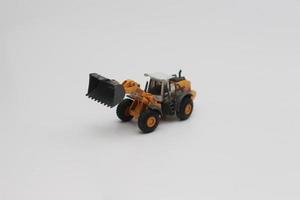 a close up of miniature orange wheel loader toy photo