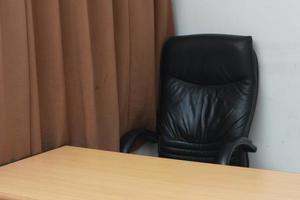 photo of a chair and desk with brown window curtains. Workspace concept photo.