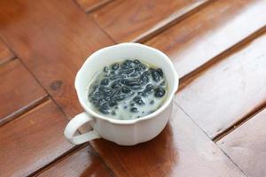 a close up of a glass of a traditional Indonesian drink called Dawet Ireng or black dawet. Indonesian traditional food photo concept.