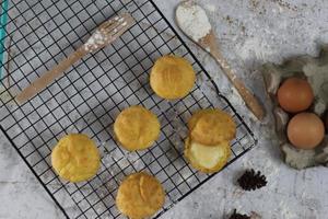 un tradicional pastel desde Indonesia llamado kue sus lleno con crema bocanadas servido en un pastel estante. comida concepto foto. foto