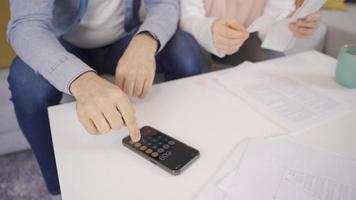 Muslim couple checking payment bills at home. Muslim Husband and wife make calculations, plan budget expenditures, discuss money. video