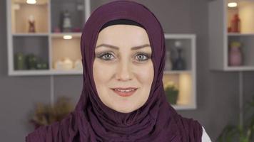 Close-up portrait of woman in hijab. Green-eyed hijab woman smiling looking at the camera. video