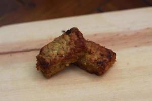 a close up of fried tempeh on a wooden cutting board photo