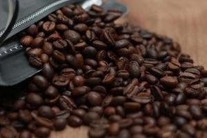 Detailed photo of coffee beans before being processed into a drink isolated on wood. Concept photo of the basic ingredients of coffee drinks.