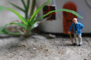 miniatura figura de un abuelo quien es esperando en frente de el casa. foto