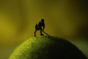 miniatura figura de un hembra granjero trabajando el tierra con un amanecer antecedentes. foto