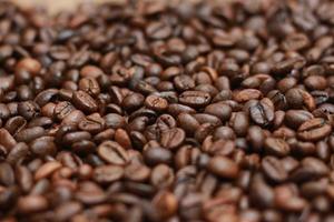 Detailed photo of coffee beans before being processed into a drink isolated on wood. Concept photo of the basic ingredients of coffee drinks.