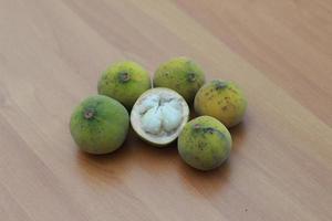 greenish yellow harp fruit isolated on money table has sweet and sour taste. Food concept photo. photo