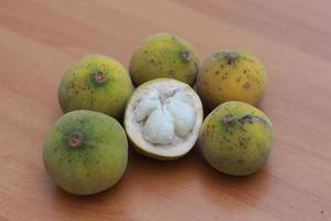 greenish yellow harp fruit isolated on money table has sweet and sour taste. Food concept photo. photo