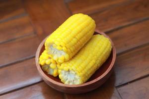 a close up of corn on the cob served in a wooden bowl. photo