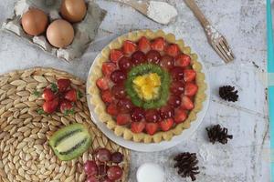 big fruit pie with toppings of strawberries, grapes, kiwi and pineapple. savory, sweet and fresh. Food concept photo. photo