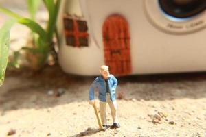 miniatura figura de un abuelo quien es esperando en frente de el casa. foto