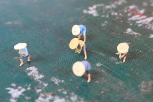 miniatura cifras de agricultores trabajando en un corte estera. concepto de agricultura foto. foto