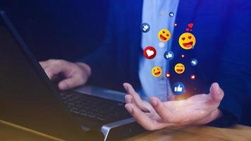 Social media and online digital concept, Businessman using laptop sending emojis with social media. photo