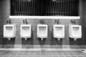 Men's room urinals discharge of waste from the body,men toilets white and black photo