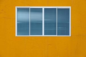 Modern glass window on the yellow wall, blanket window frame photo