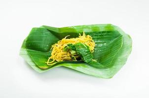 Fried dry yellow noodles on a banana leaf  on white background,thai food style photo