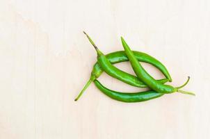 fresh green hot chilli peppers with spicy on the wooden photo