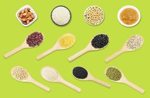 Collection set of beans and sesame on wooden spoons isolated on green background,top view photo