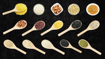 Collection set of beans and sesame on wooden spoons isolated on dark background,top view photo