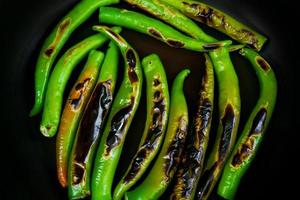 asado verde caliente chile pimientos directo fuego, un método de peladura pimientos usado en muchos platos de el mexicano gastronomía foto