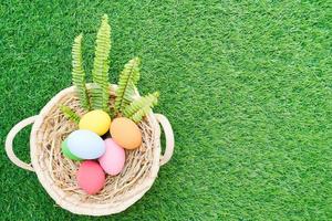 Pascua de Resurrección huevos en el cesta en césped foto